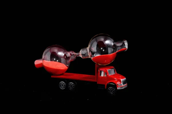 Time Transportation Concept Hourglass Watch Red Toy Truck Black Background — Stock Photo, Image