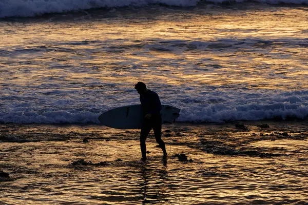 Surfer o zachodzie słońca na spokojnym oceanie — Zdjęcie stockowe