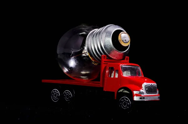 Electric Power Concept Red Truck Light Bulb Black Background — Stock Photo, Image