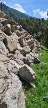 İnanılmaz su barajı, taşlarla dolu, dağlar ve ağaçlarla çevrili.
