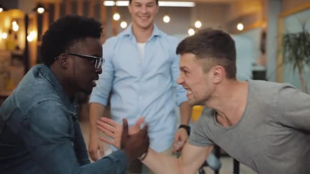 Guerre en fonction. Deux équipes se font concurrence dans un bureau moderne. Armwrestling, glisser des dossiers, jeter du papier l'un l'autre. Mouvement lent .