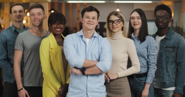 Retrato de jóvenes empresarios sonriendo y mirando a la cámara. Concepto de: internacionalidad, startup, carrera, negocio de éxito, equipo . — Vídeo de stock