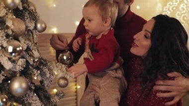 Noel ağacının yanında, Noel ağacının yanında, Noel ağacını süsleyen anne kucağında bebek, baba süslemesi Noel balosunda mutlu bir beyaz aile..
