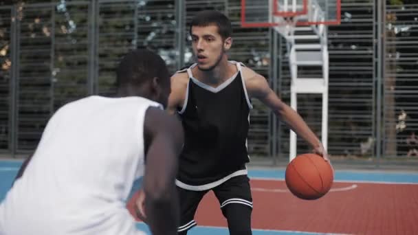 Close Up of Two Young Mixed Race Active Guys Playing Basketball, One on One on the Street Sports Basketball Court. Espíritu de la competencia. Concepto de estilo de vida saludable y deporte . — Vídeo de stock