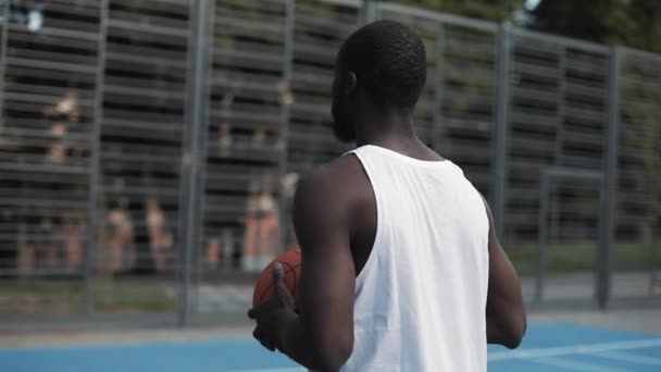 Svalnatý Afroameričan, který úspěšně házel míč do koše Raduje se z toho, že vypadá šťastně a spokojeně na pouličním basketbalovém hřišti. Zdravý životní styl a sportovní koncepce. 360 Video v pomalém pohybu. — Stock video