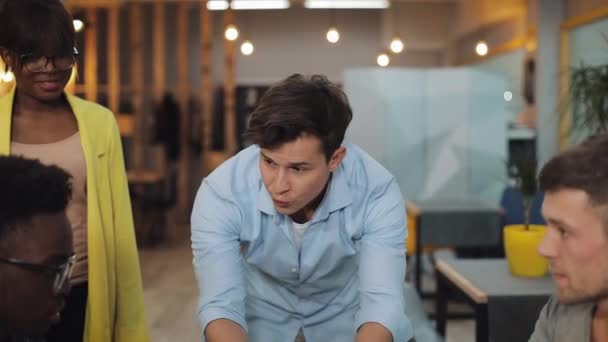 Guerre en fonction. Deux équipes se font concurrence dans un bureau moderne. Armwrestling, glisser des dossiers, jeter du papier l'un l'autre. Mouvement lent .