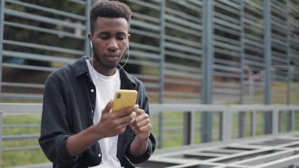 Millennial usando celular em fones de ouvido . — Vídeo de Stock