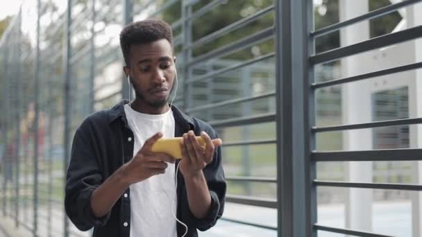 African man watching videos on mobilephone. — Stock Video