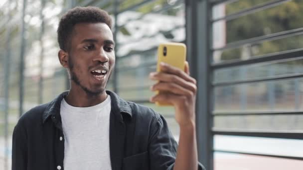 Hombre joven utilizando la comunicación de vídeo en el teléfono inteligente . — Vídeos de Stock