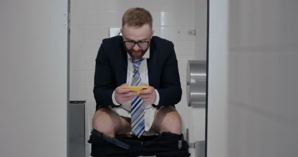 शौचालयात ऑनलाइन गेम खेळत सूट मध्ये फ्रीलांसर . — स्टॉक व्हिडिओ
