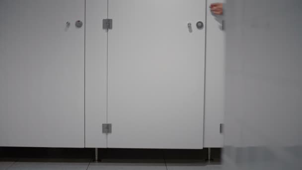 Affärsman som springer in i toalettkabinen. — Stockvideo
