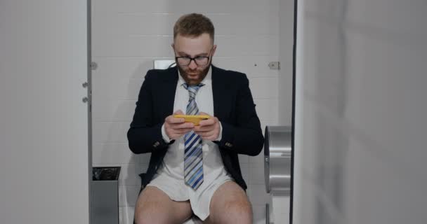 Uomo toccando schermo e giocando in wc . — Video Stock