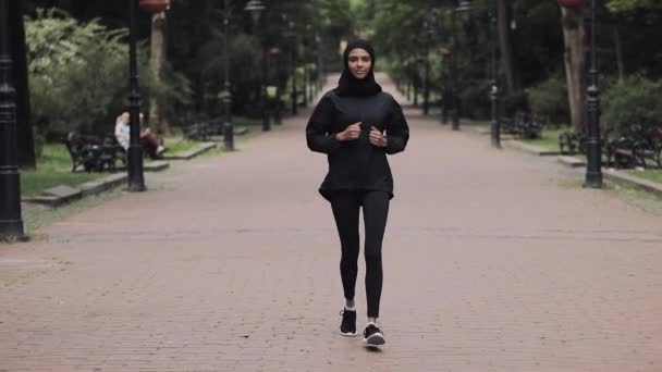 年轻的虔诚的穆丝琳女孩穿着一件Hijabt跑步在公园里。 健康生活方式概念. — 图库视频影像