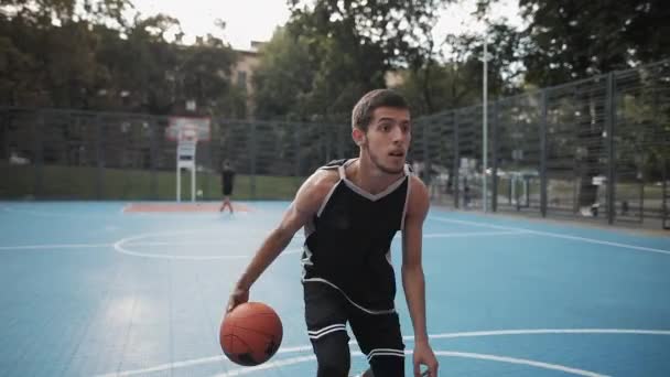 Молодой кавказский спортсмен имеет баскетбольную подготовку. Кавказский парень, играющий в мяч, бросающий и набирающий очки на городской спортивной баскетбольной площадке. Концепция здорового образа жизни и спорта . — стоковое видео