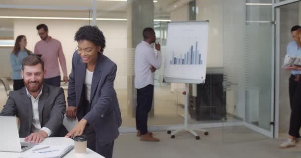 Groupe joyeux de travailleurs multiethniques applaudissant et debout dans la salle de bureau. Les femmes et les hommes employés de bureau rencontrent et saluent quelqu'un qui a l'air heureux, geste bon .