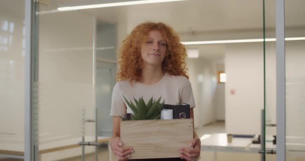 Jonge ontslagen vrouw loopt droevig en houdt doos met haar bezittingen. Jonge vrouwelijke werkneemster ontslagen met box en multi-etnische collega 's die haar symphathiseerden. Begrip werk. — Stockvideo