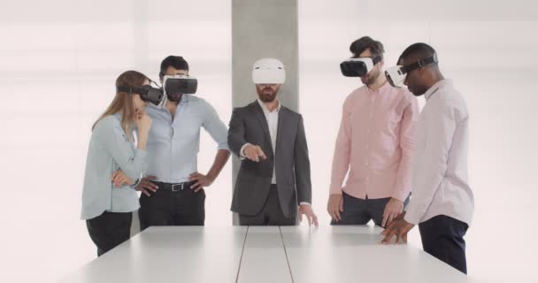 Squadra di giovani impiegati multietnici che utilizzano occhiali di realtà virtuale durante una riunione di lavoro in sala conferenze. Gruppo di dipendenti con occhiali VR. Concetto di lavoro, tecnologia . — Video Stock