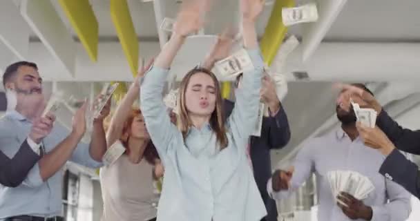 Groupe de personnel de bureau multiracial célébrant la promotion de la jeune colégue féminine. Jeune heureuse équipe masculine et féminine faisant la fête, dansant et jetant de l'argent. Concept de carrière et de réussite .