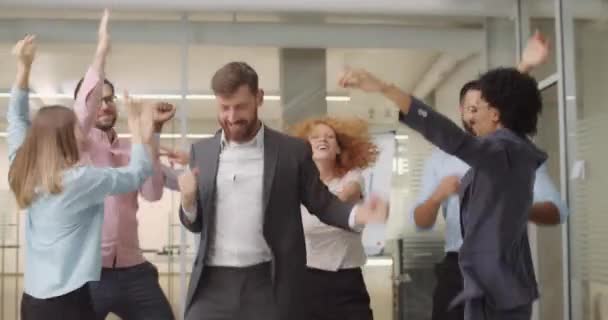 Young diverse business workers in good mood having fun together after finishing working day. Group of managers dancing, smiling and rejoicing. Concept of people, work, positive emotions. — Stock Video