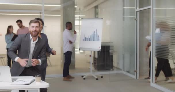 Trabajadores de oficinas multiétnicos saludan al nuevo director ejecutivo corporativo entrando en la sala. Personal de negocios masculino y femenino aplaudiendo, animando a su colega. Vista de cámara. En interiores . — Vídeo de stock