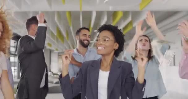 Empresária africana atraente celebrando a vitória com seus colegas de trabalho. Grupo multiétnico de trabalhadores de escritório que dançam em notas em queda. Chuva de dinheiro. Conceito de negócio bem sucedido . — Vídeo de Stock