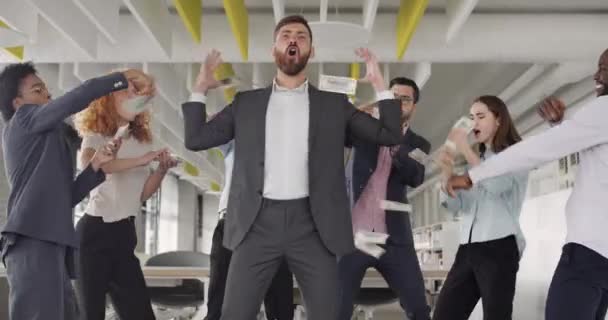 Heureux groupe de travailleurs qui se réjouissent du succès du projet et dansent heureux. Jeune mélange de personnel de bureau ethnique s'amuser et disperser de l'argent dans le bureau moderne. Concept de victoire, victoire .