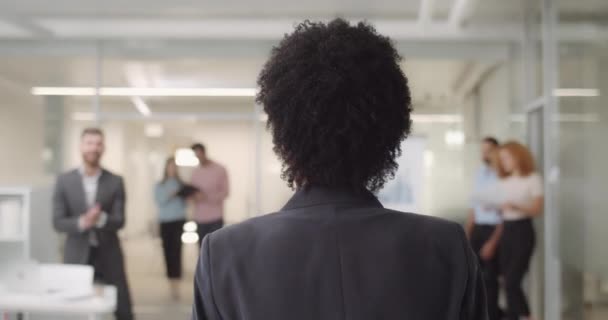 Erfolgreiche afrikanische Geschäftsfrau betritt modernes Büro. Das Team der Büroangestellten und Büroangestellten klatscht und gratuliert ihrem Chef zum Sieg. drinnen. Rückseite. — Stockvideo