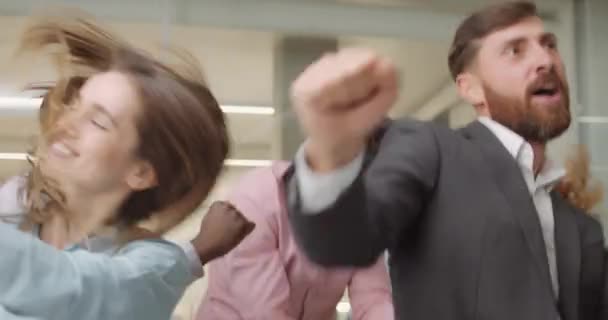 Close up of excited workers cutting loose in office workspace. Overjoyed office staff dancing, smiling, celebrating end of work week. Concept of people, work, positive emotions. — Stock Video