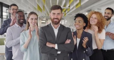 Karışık etnik ofis çalışanları erkek patronlarını alkışlıyor ve gülümsüyor. Ofis çalışanlarının portresi CEO 'larını başarıyla kutluyor. İş anlayışı, zafer.