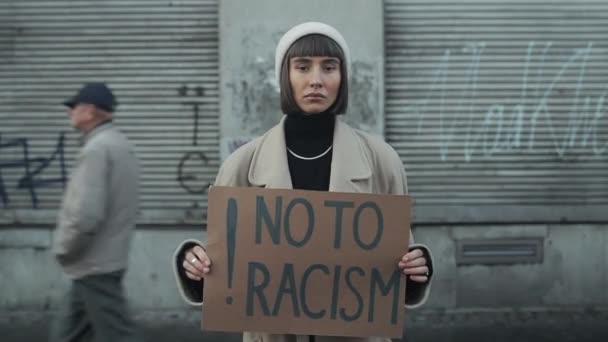 Lviv, Ουκρανία - 27 Νοεμβρίου 2019: Λήξη χρόνου. Κορίτσι hipster κρατώντας πανό κατά του ρατσισμού στέκεται έξω. Γυναικεία χιλιετηρίδα με ρύγχος που υποστηρίζει το κίνημα για ίσα ανθρώπινα δικαιώματα. — Αρχείο Βίντεο