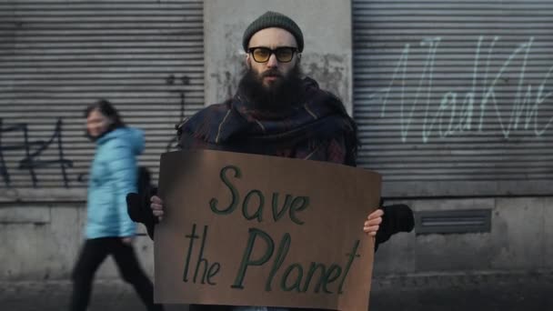 Lviv, Ucrânia - 27 de novembro de 2019: Ativista segurando o slogan de agitação Save Planet. Homem lutando contra a poluição ecológica. Desfasamento temporal. Conceito de ecologia proteção ambiental. Fundo de rua . — Vídeo de Stock