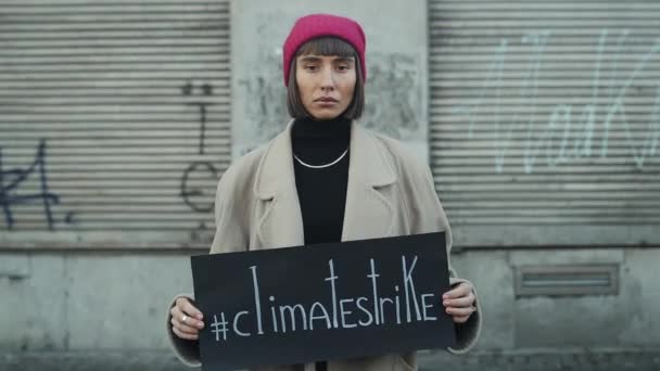 Lviv, Ucrania - 27 de noviembre de 2019: Niña milenaria protestando contra la contaminación ambiental. Muchacha infeliz sosteniendo señal de huelga climática. Mujer de pie al aire libre con pancarta — Vídeos de Stock