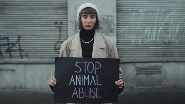 Lviv, Ukraine - November 27, 2019: Time lapse. Young woman holding banner against animal abusing and standing outdoors. Student girl supporting animal protection campaign — 비디오