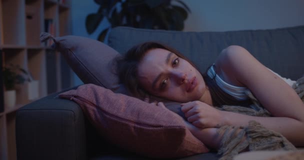 Close up of frustrated young girl in depression lying on sofa with pillow under her head . Unhappy young woman having relationship problems. Concept of negative feeling and worries. — Stock Video