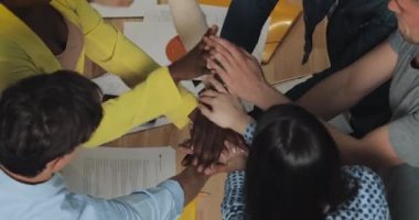 Çok ırklı iş adamları ofiste ellerini bir arada tutarken. Başarı iş , start-up , takım çalışması kavramı.