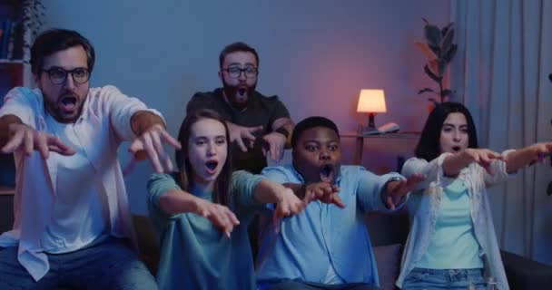 Multiethnic group of happy friends having fun together and doing wave while sitting in front of TV. Young people supporting team while watching sport at home. Concept of leisure. — Stock Video