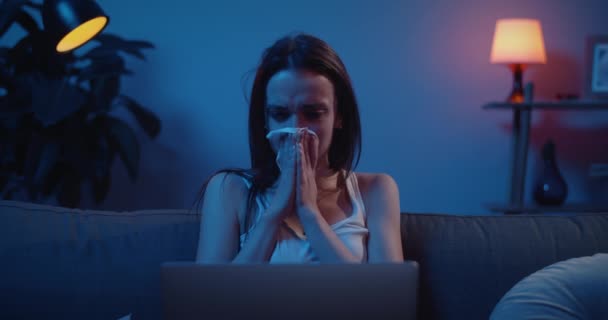 Front view of young girl crying hardly while watching bad news on her laptop. Upset young woman with tears on her face using paper hanierchief. Concept of tragedy, drama and emotions. — Stock Video