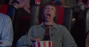 Genç hippi kadının filmdeki heyecan verici ana huşu içinde yaklaşması. Sinemada film izleyen kız, ağzı açık ve patlamış mısır yerken kocaman gözleri olan..