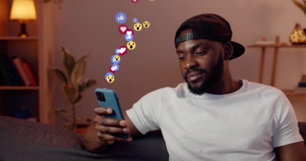 뉴욕: 2020 년 2 월 4 일: 가정에서 스마트폰을 사용하는 남자. 사용자 인터페이스가 있는 애니메이션 - 좋아 하는, 미소, 추종자, 코멘트. 소셜 미디어와 알림 아이콘. — 비디오
