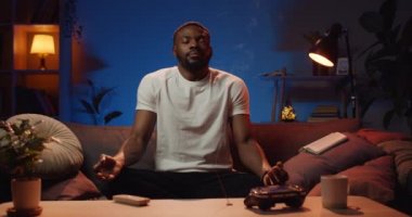 Şu ana kadar Lotus pozisyonunda oturan rahat genç adamın gözleri kapalı önü. Sakin yakışıklı adam nefes alıyor ve tütsü çubuklarıyla odada meditasyon yapıyor. Zen kavramı.