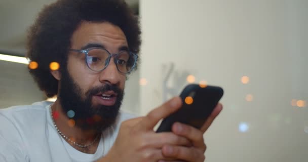 Close up of man in 30s using his smartphone and making surprised face expression. Handsome mature guy looking surprised while checking notification. Concept of good news. — Stock Video