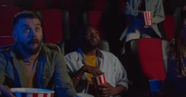 Heyecanlı uzay araçları film başlarken koltukları tutuyorlar. Genç Afrikalı patlamış mısır yiyip film seyrederken diğer insanlar yerlerini alıyor. Boş zaman ve eğlence anlayışı.