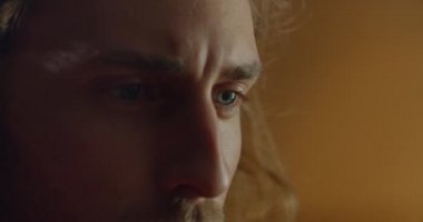 Sanat objesi yaratırken genç ve yakışıklı bir adamın yüzüne yakından bakın. Uzun saçlı ve mavi gözlü milenyum adamı işine odaklanmış. El yapımı sanat ve yaratıcılık kavramı..