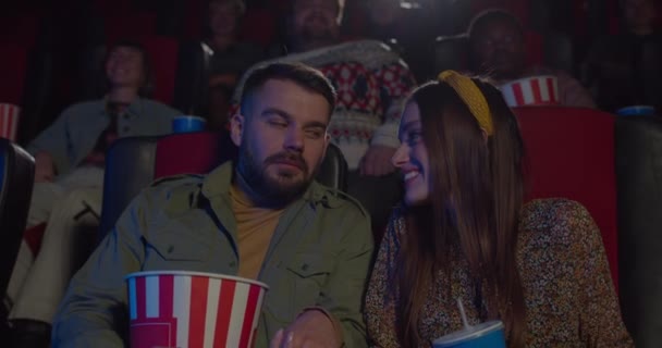Un homme et une femme attirants regardant des films drôles et souriant au cinéma. Jeune couple enjoignant le film et parlant tout en ayant rendez-vous au cinéma. Concept d'émotions positives . — Video