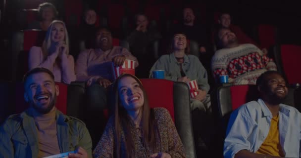 Vooraanzicht van multi-etnische toeschouwers die grappige films kijken in de bioscoop. Mensen in de bioscoop lachen om komedie in de bioscoop. Vrolijke mensen kijken naar komedie film. Concept entertainment. — Stockvideo