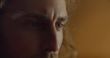 Sanat objesi yaratırken genç ve yakışıklı bir adamın yüzüne yakından bakın. Uzun saçlı ve mavi gözlü milenyum adamı işine odaklanmış. El yapımı sanat ve yaratıcılık kavramı..