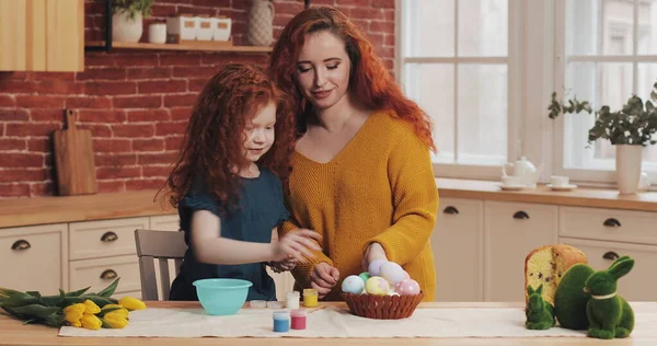 Annem ve küçük kızı Paskalya için hazırlanıyorlar. Mutlu aile, sıcak mutfakta paskalya yumurtası boyamaya hazırlanıyor.