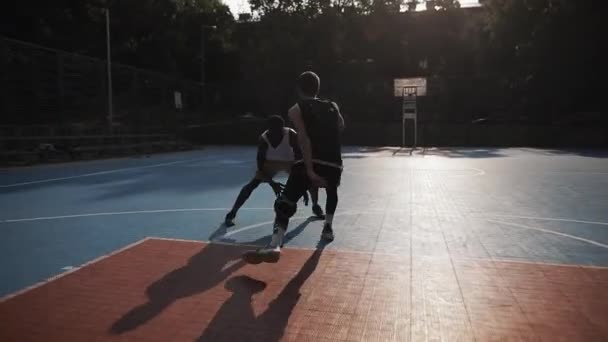 Två unga aktiva Mixed Race killar som spelar basket, studsande boll, en på en utanför, Afro American Scoring en boll på Urban Sports Basket Court. Hälsosam livsstil och idrott koncept. — Stockvideo