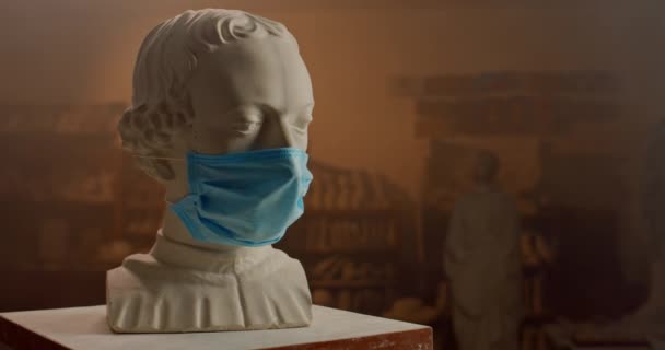 Παλιά αντίκα λευκό μαρμάρινο γλυπτό προτομή φορώντας ιατρική μάσκα. Concept of art on qurantine.Εργαστήριο γλυπτών στο παρασκήνιο. — Αρχείο Βίντεο