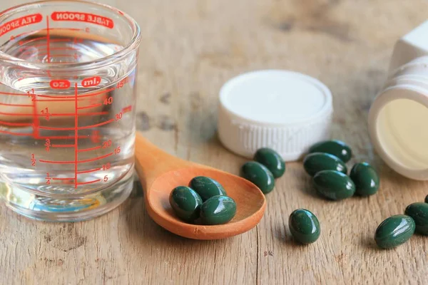 Pílulas de vitaminas na madeira — Fotografia de Stock